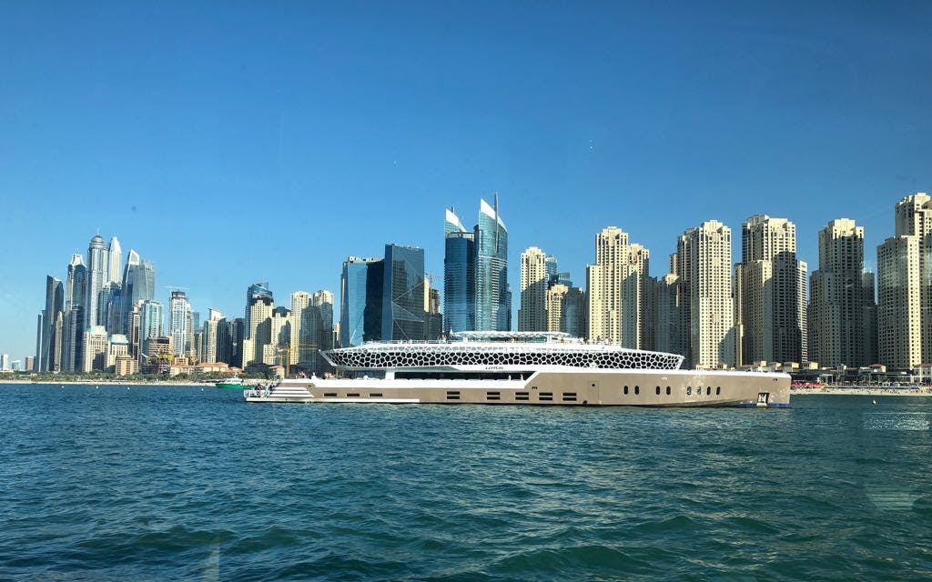 Lotus Mega Yacht cruising near Dubai Marina skyline.