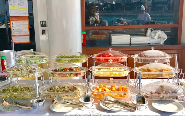 Buffet spread on Lotus Mega Yacht Weekend Brunch Cruise with assorted fruits and dishes.