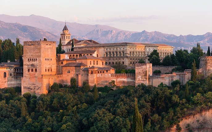 Alhambra Palace and Generalife gardens in Granada, Spain, with mountainous backdrop.