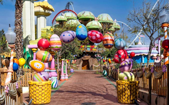 Colorful Easter decorations at PortAventura Park entrance, featuring large painted eggs and festive displays.