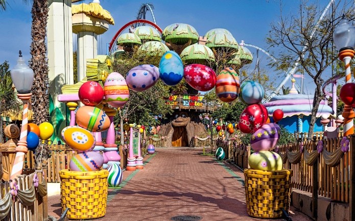 Colorful Easter decorations at PortAventura Park entrance, featuring large painted eggs and festive displays.