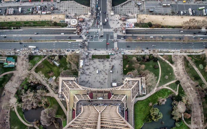 Aerial view from Eiffel Tower summit overlooking Paris streets and gardens.