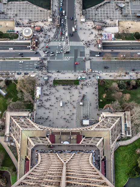 Aerial view from Eiffel Tower summit overlooking Paris streets and gardens.
