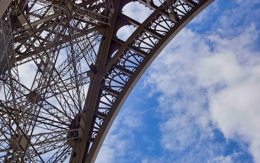 Eiffel Tower iron lattice detail against blue sky, Paris.