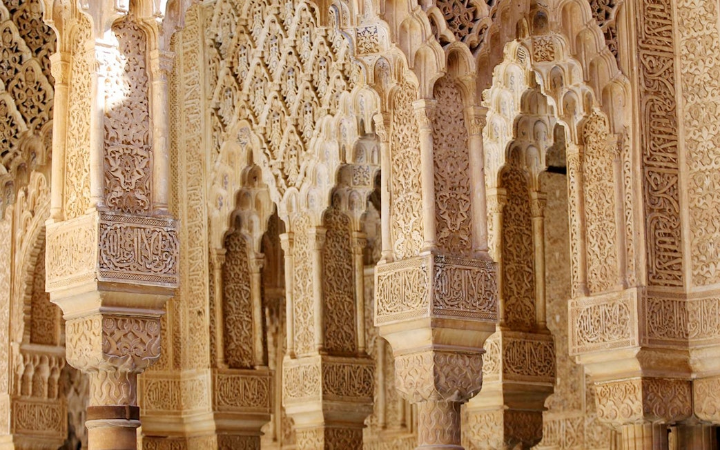 Intricate Moorish arches in the Nasrid Palaces, Alhambra, Granada.