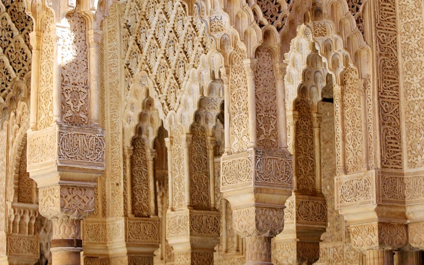 Intricate Moorish arches in the Nasrid Palaces, Alhambra, Granada.