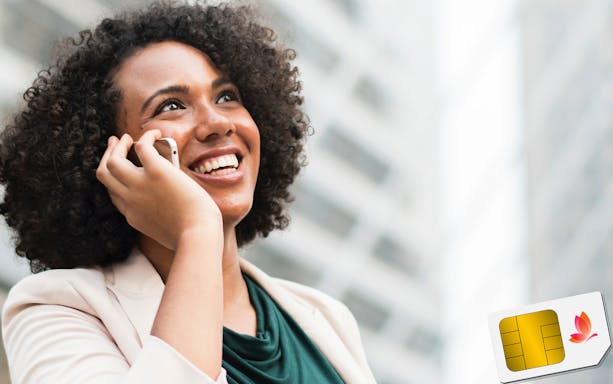 Woman using phone with Dubai SIM card in urban setting.