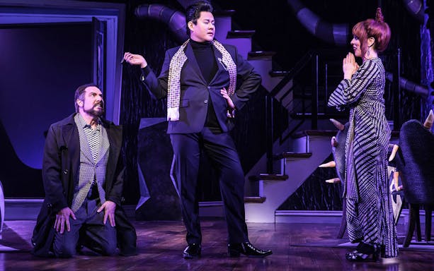 Actors performing a scene from the Beetlejuice musical on stage.