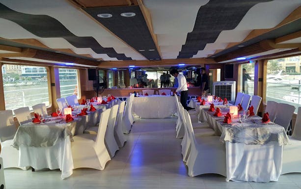 Dining setup on Mega Yacht Dinner Cruise by Westin with tables and chairs.