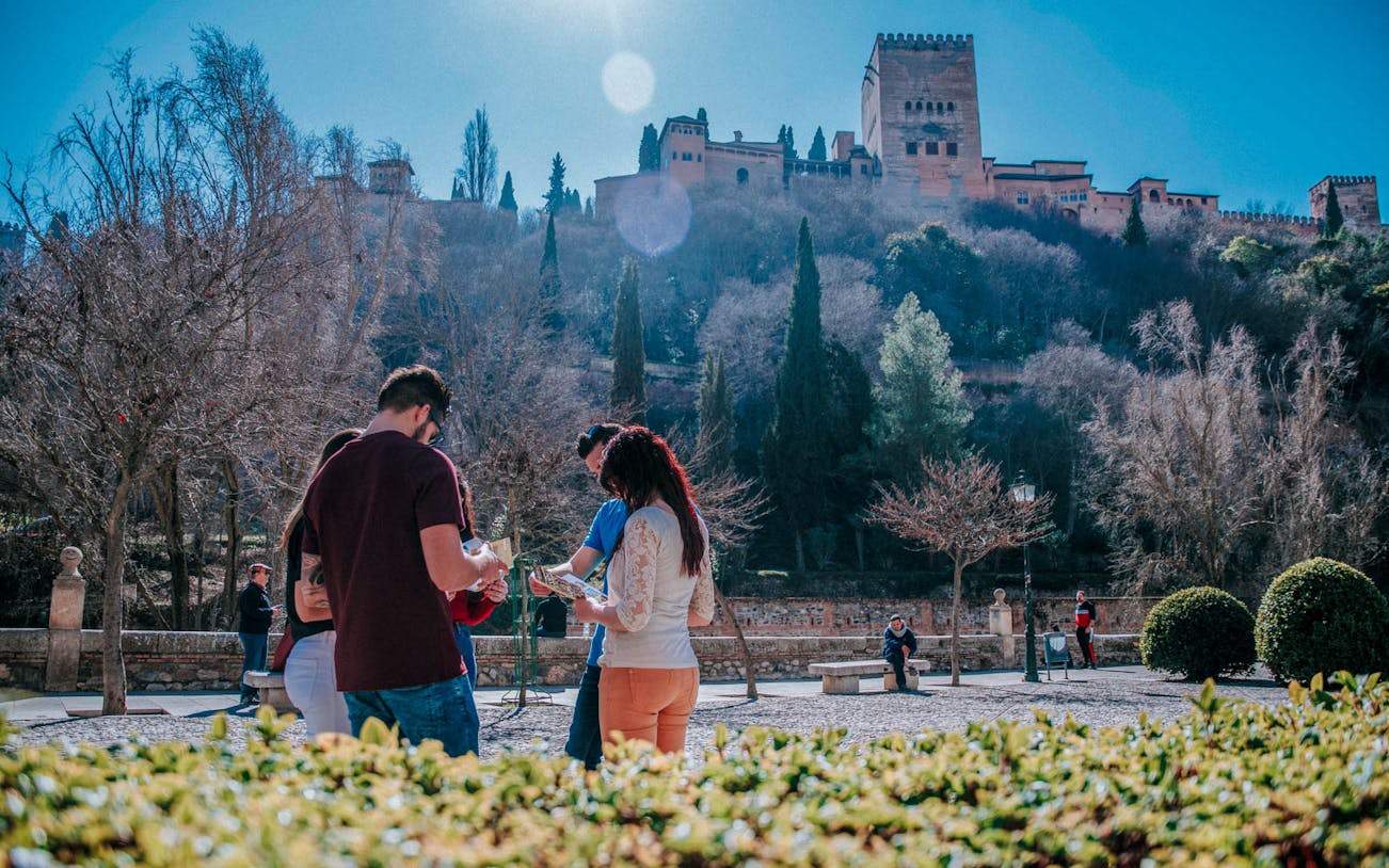 Group of tourists exploring Alhambra with guide during Historic Center & Albaycin Walking Tour.