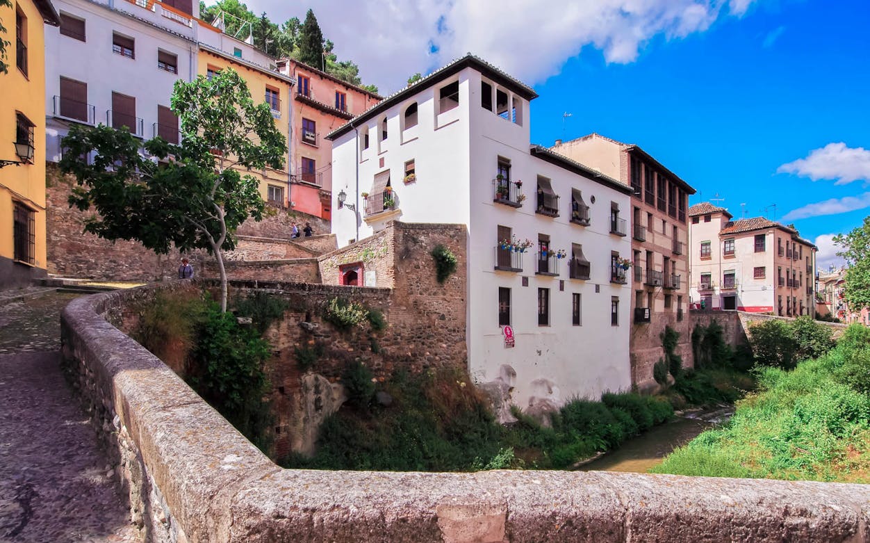 Historic Albaycin neighborhood with traditional buildings and cobblestone path in Granada, Spain.