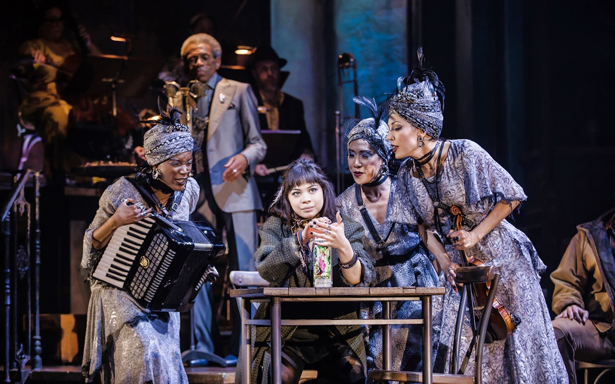 Performers on stage during a scene from Hadestown musical.