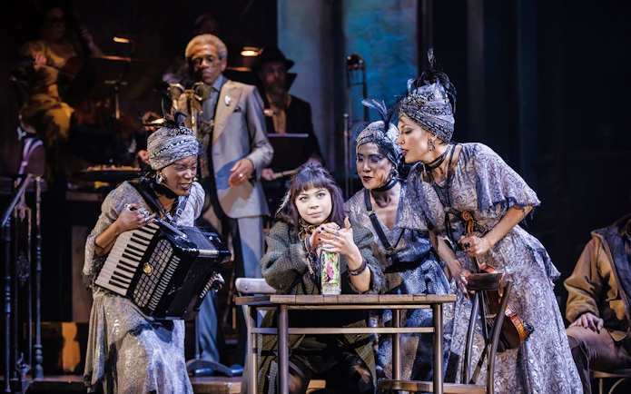 Performers on stage during a scene from Hadestown musical.