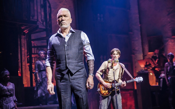 Stage scene from Hadestown musical with performers in character.