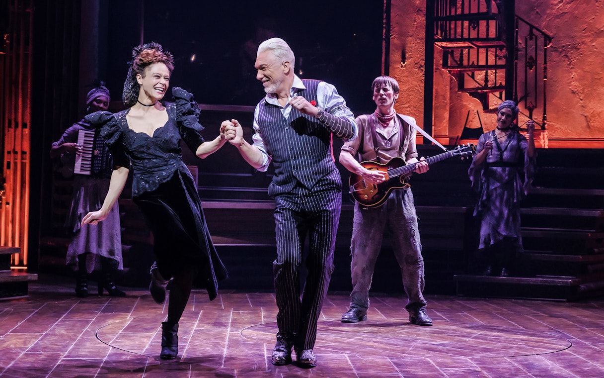 Performers dancing on stage during a Hadestown musical scene.