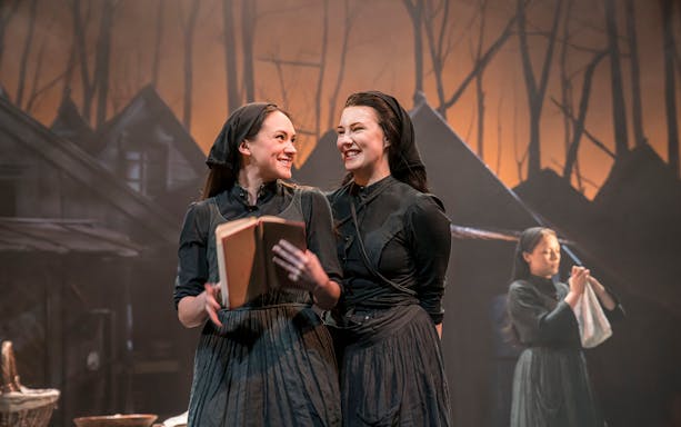 Actors performing a scene from "Fiddler On The Roof" on stage.