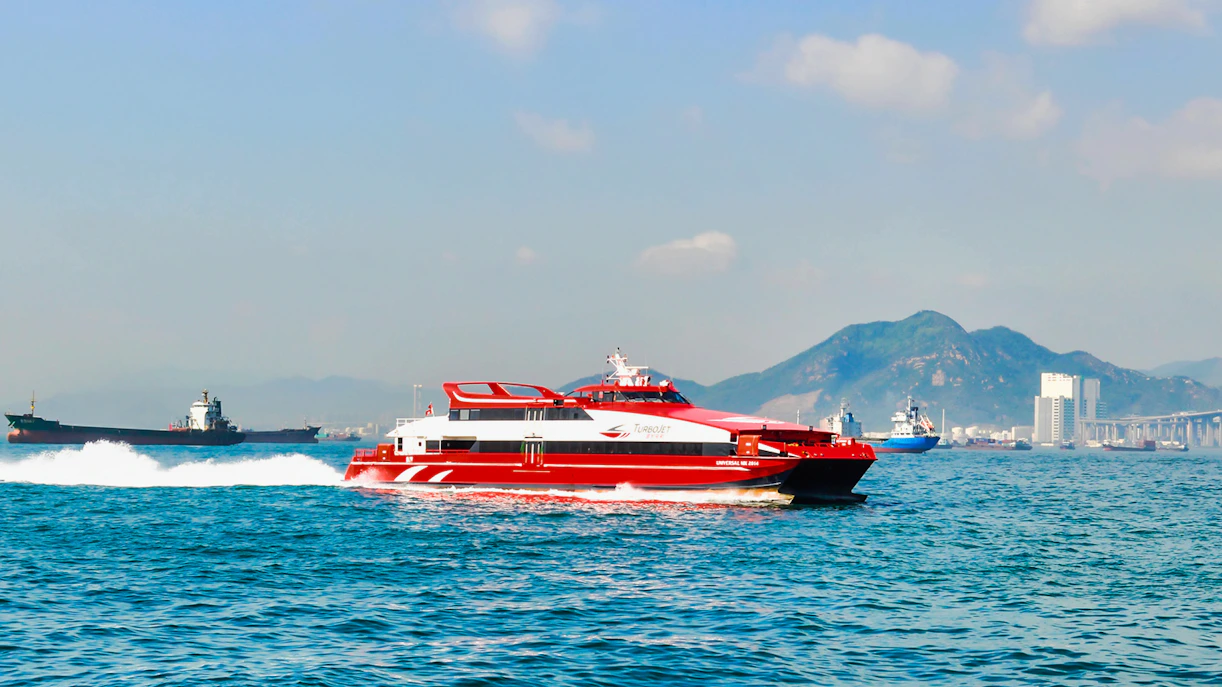 TurboJet ferry cruising from Tuen Mun with Hong Kong skyline in the background.