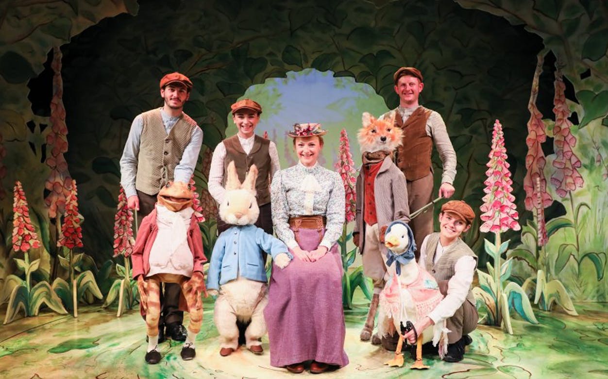 Stage performance of "Where is Peter Rabbit?" with actors and animal puppets.