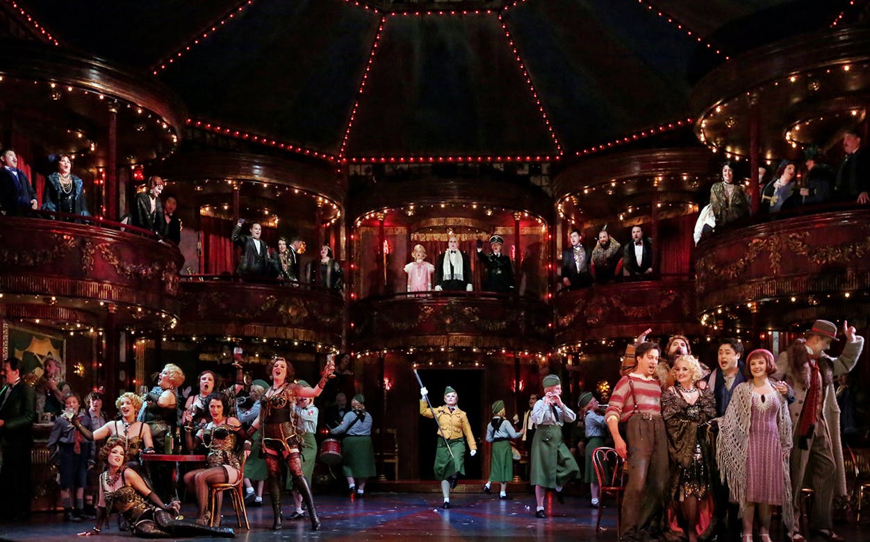 Opera performance at Sydney Opera House with singers and actors on stage and balconies.