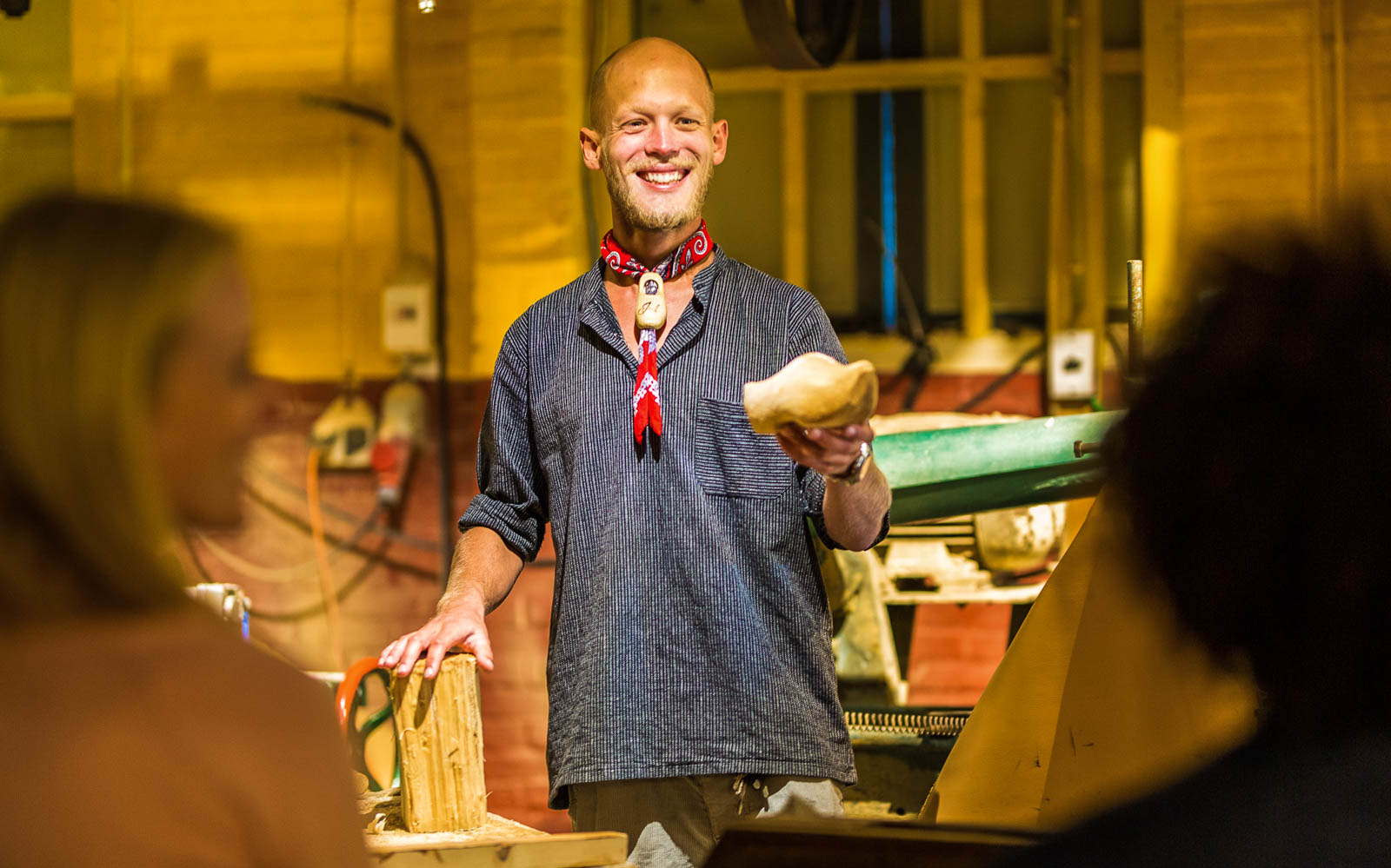 Man demonstrating traditional clog making at Zaanse Schans during Amsterdam City Tour.