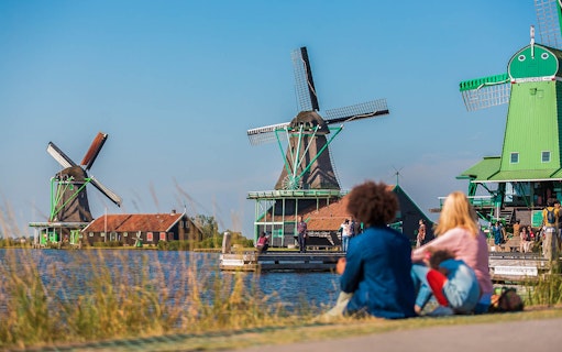 Windmills at Zaanse Schans with visitors, part of Amsterdam City Tour.