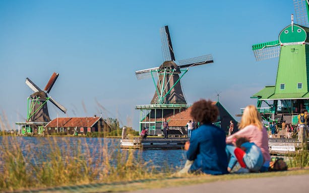 Windmills at Zaanse Schans with visitors, part of Amsterdam City Tour.