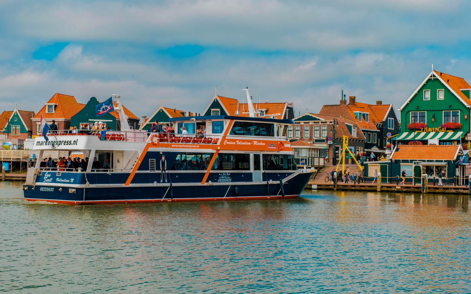 Ferry at Volendam harbor with traditional Dutch houses, part of Zaanse Schans and Amsterdam City Tour.