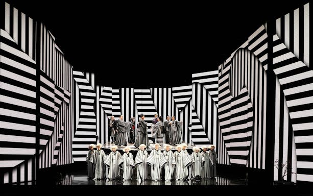 Opera performers on stage with black and white striped set design during Madama Butterfly.