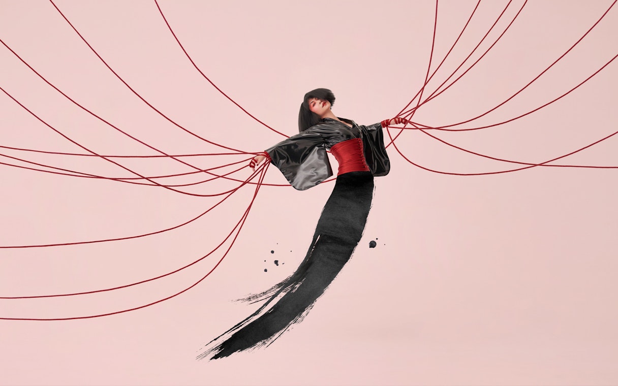 Performer in traditional attire with red cords, inspired by Madama Butterfly.