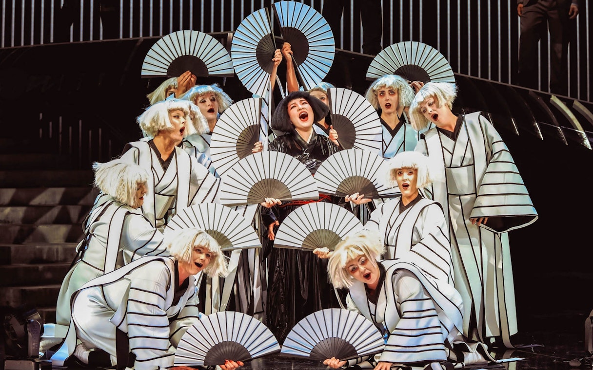 Performers in traditional costumes with fans in a scene from Madama Butterfly.