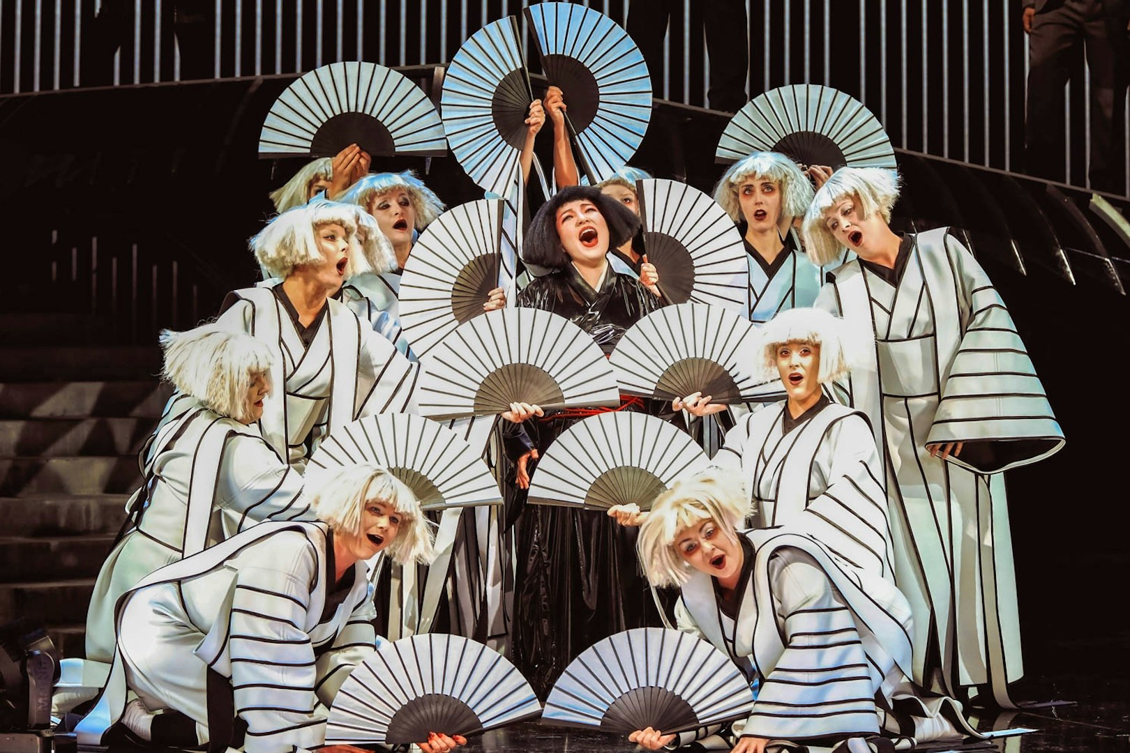 Performers in traditional costumes with fans in a scene from Madama Butterfly.