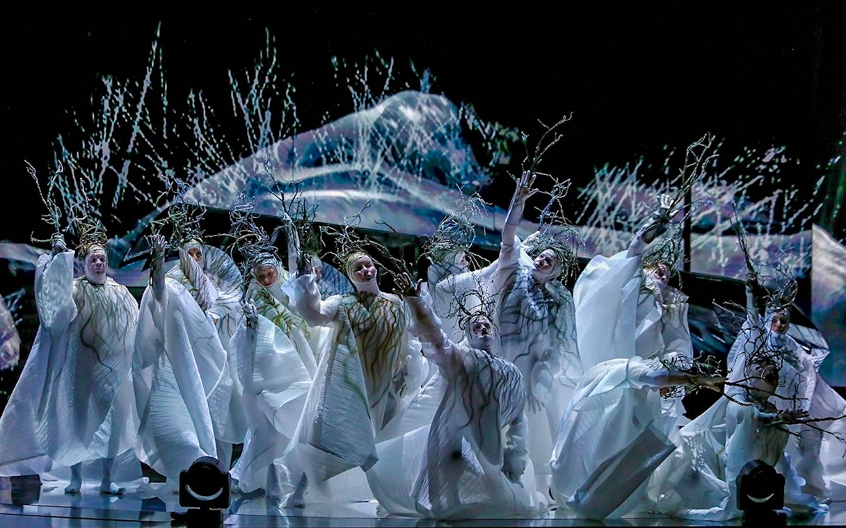 Performers in white costumes with branches in Madama Butterfly opera scene.