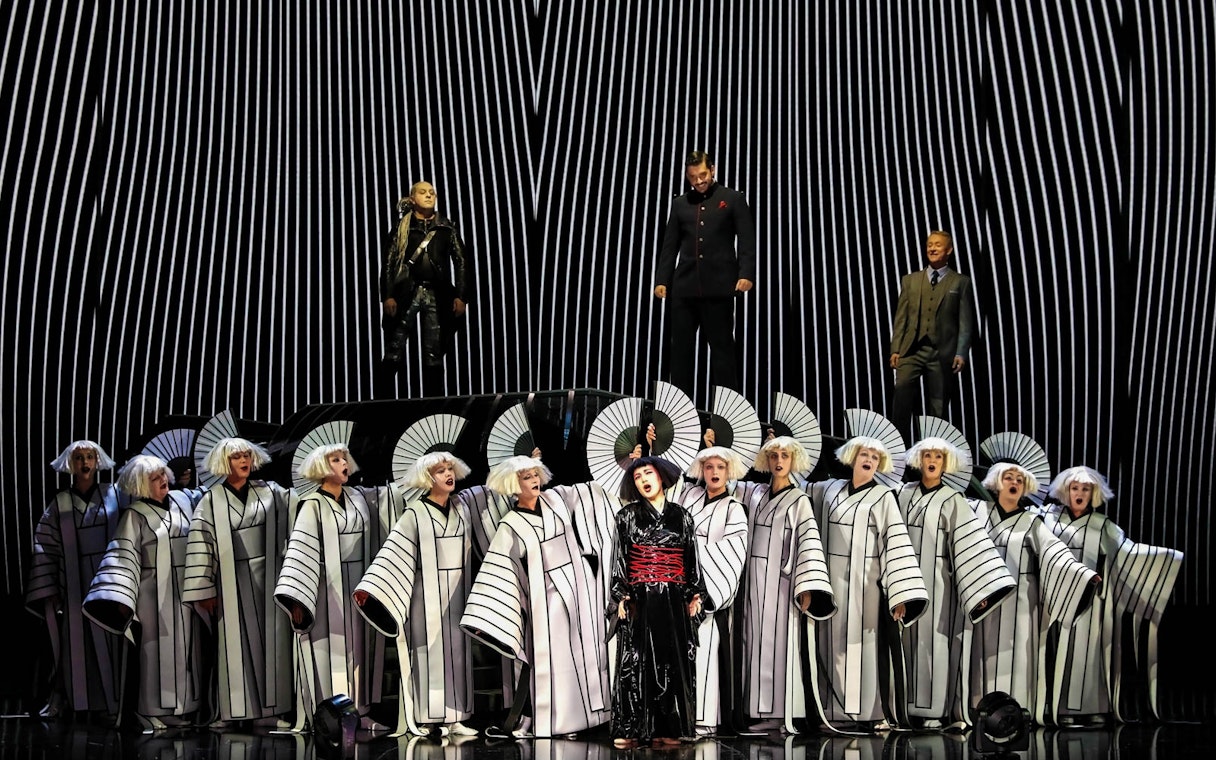 Opera performers in traditional costumes during a Madama Butterfly scene.