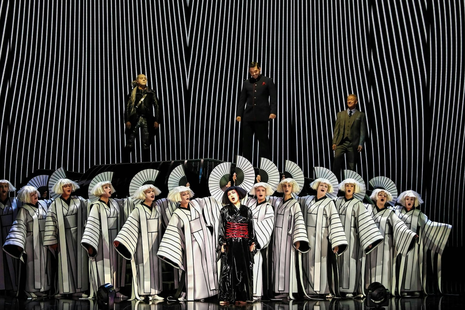 Opera performers in traditional costumes during a Madama Butterfly scene.