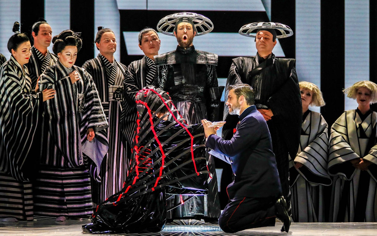 Opera performers in traditional costumes during a scene from Madama Butterfly.