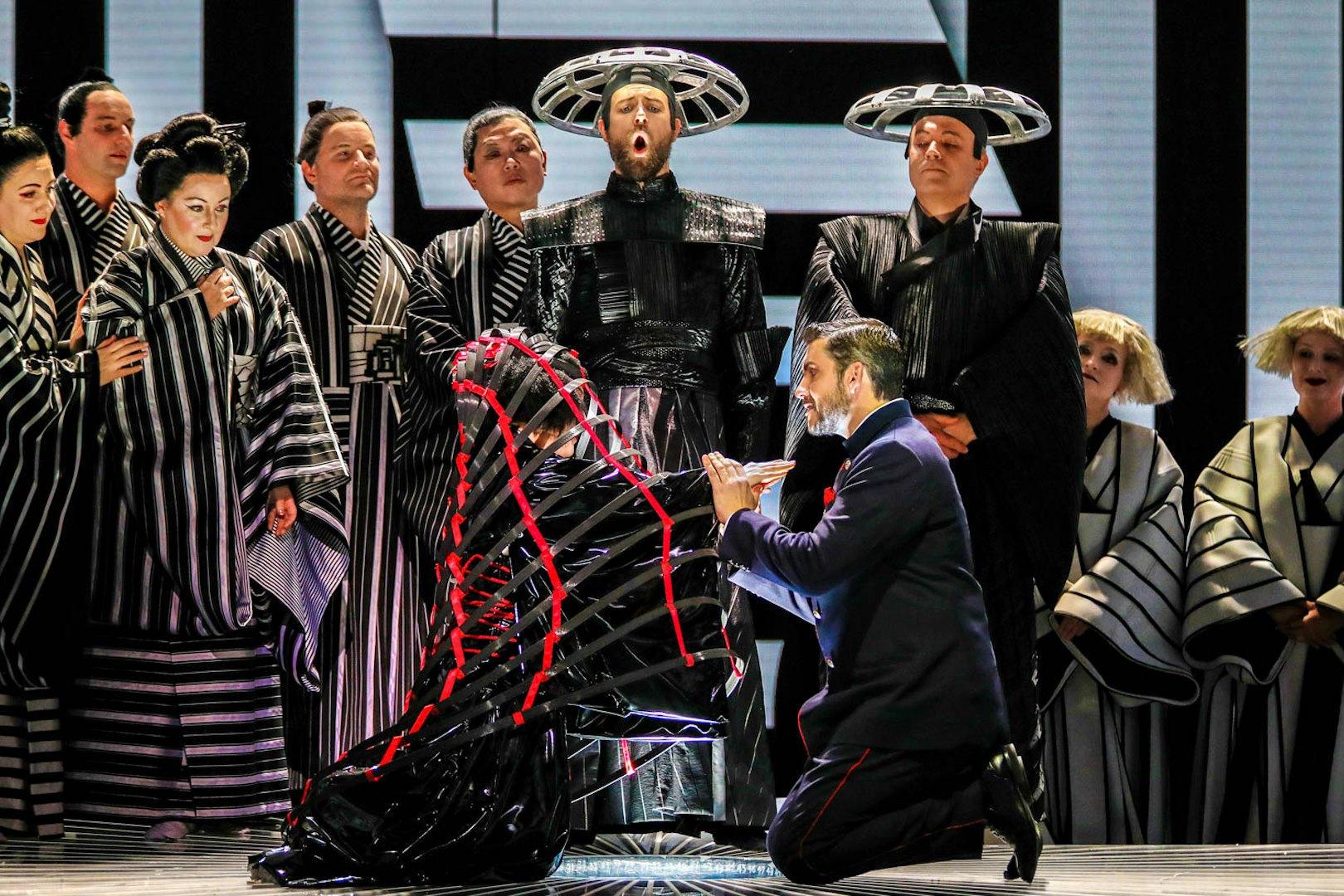 Opera performers in traditional costumes during a scene from Madama Butterfly.