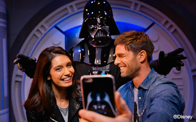Visitors taking a selfie with a character at Disney Park.