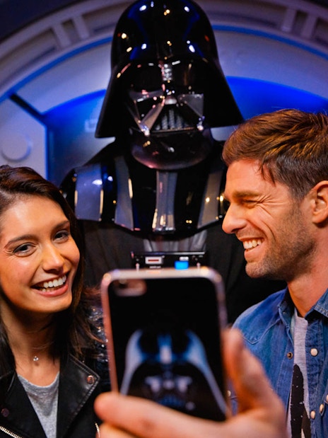 Visitors taking a selfie with a character at Disney Park.