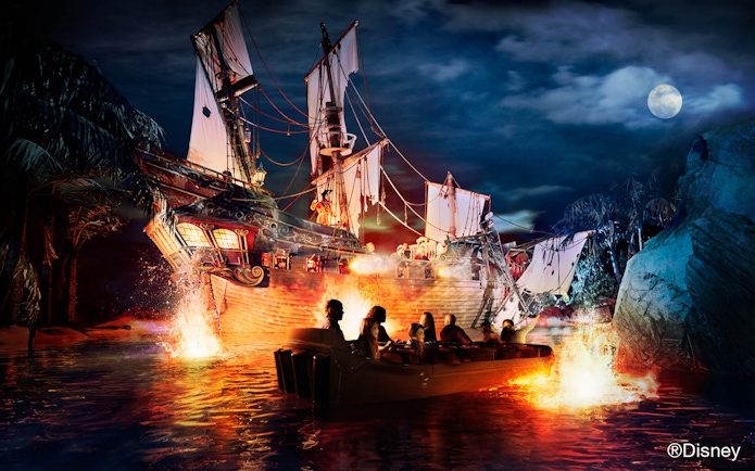Boat ride near a pirate ship at night in Disney Park.