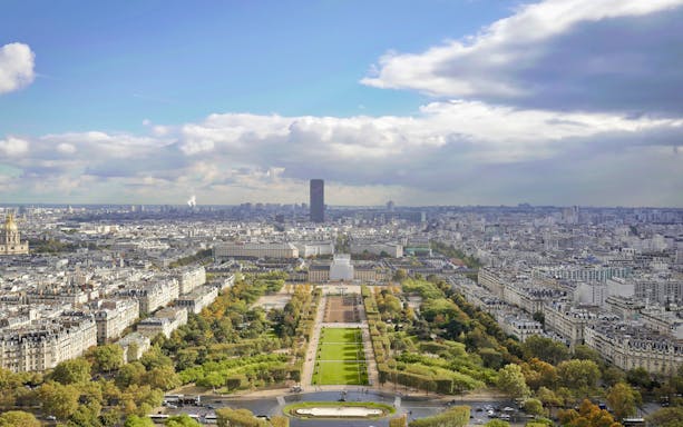View of Paris from the Eiffel Tower elevator tour, featuring Champ de Mars and cityscape.