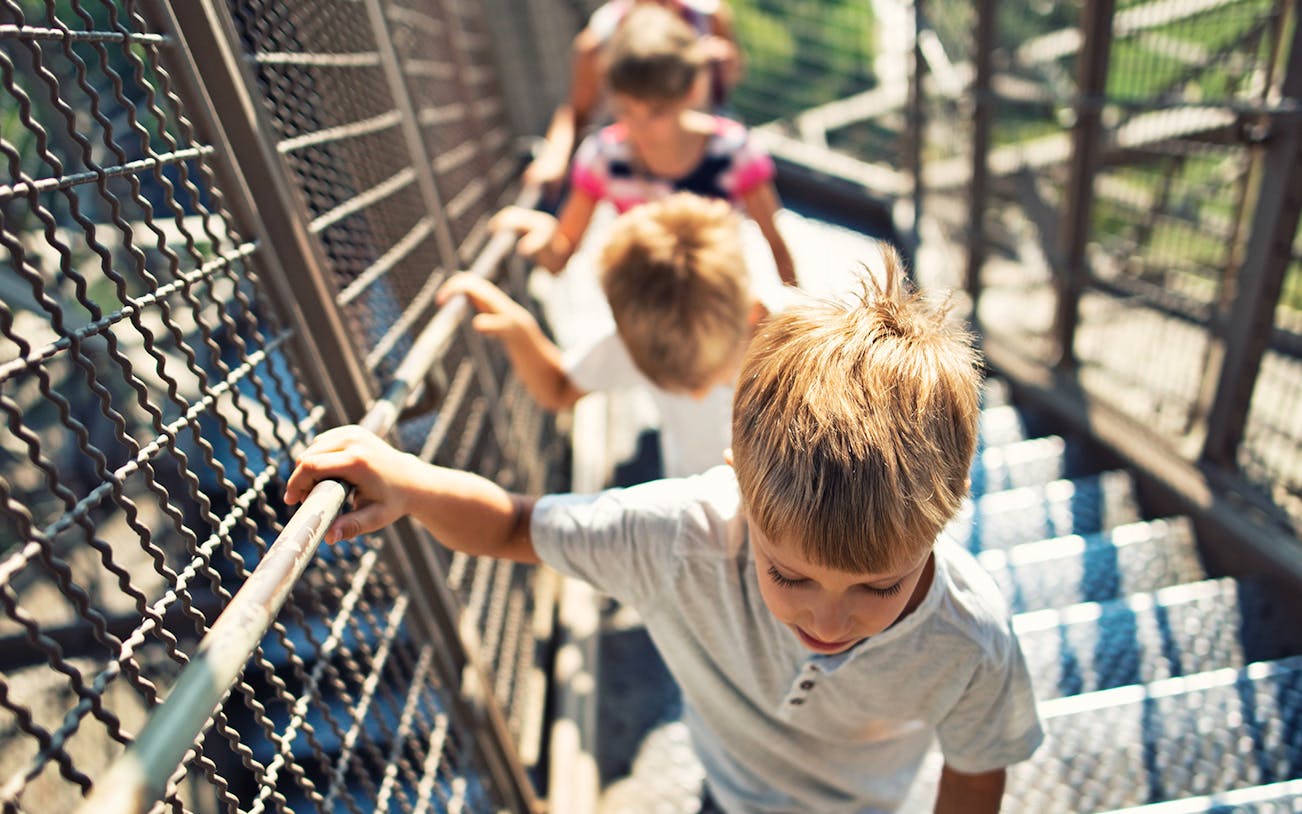 Children climbing stairs on the Eiffel Tower guided tour in Paris.