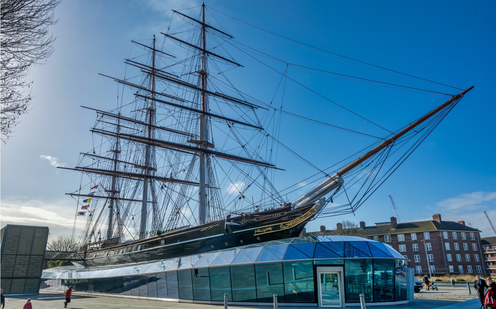 Cutty Sark ship in Greenwich, London, with modern glass entrance below.