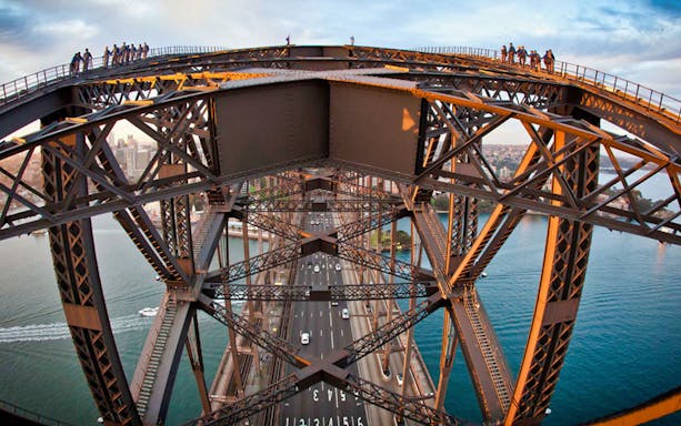 Climbers on Sydney Harbour Bridge during BridgeClimb Summit with city and water views.