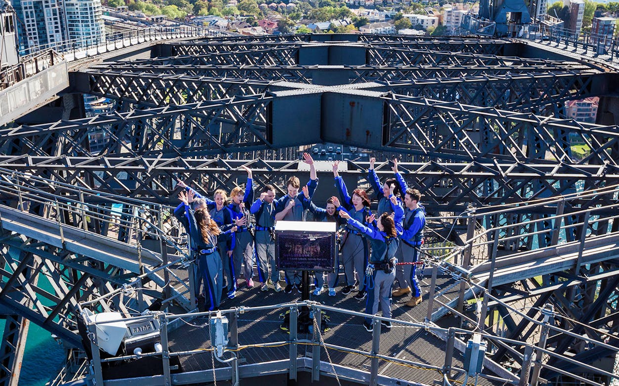 Group of people celebrating at the top of Sydney Harbour Bridge during BridgeClimb Summit Sampler.