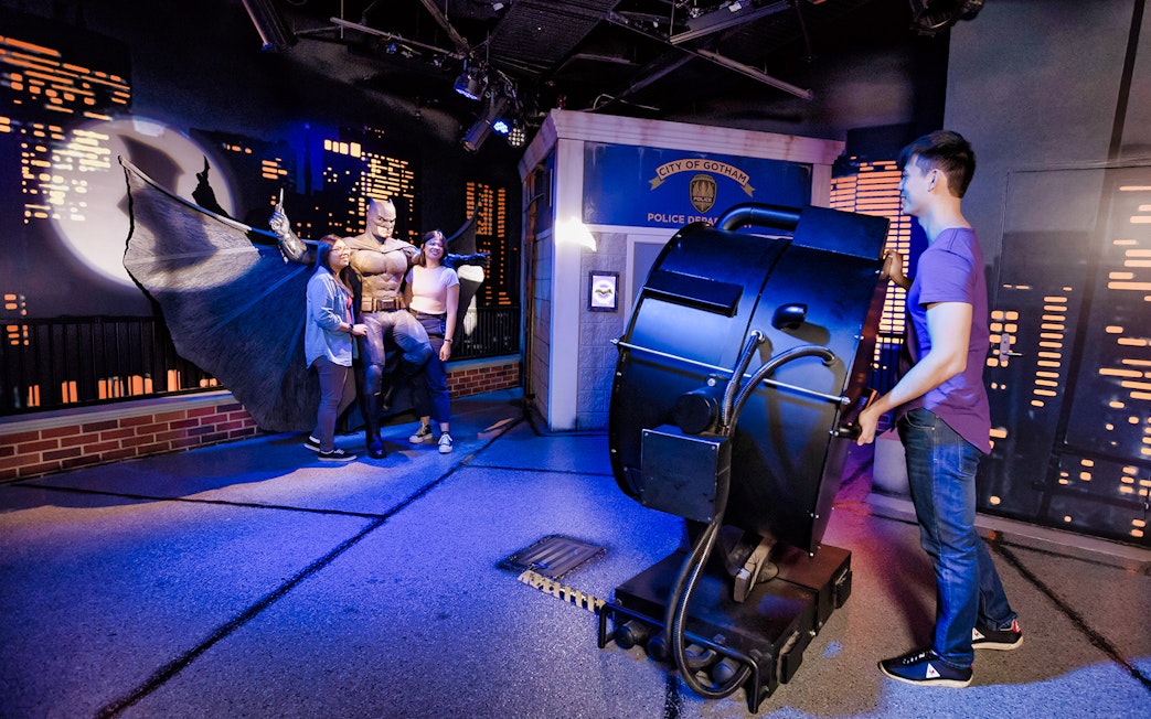 Visitors posing with a superhero figure at Madame Tussauds Sydney.
