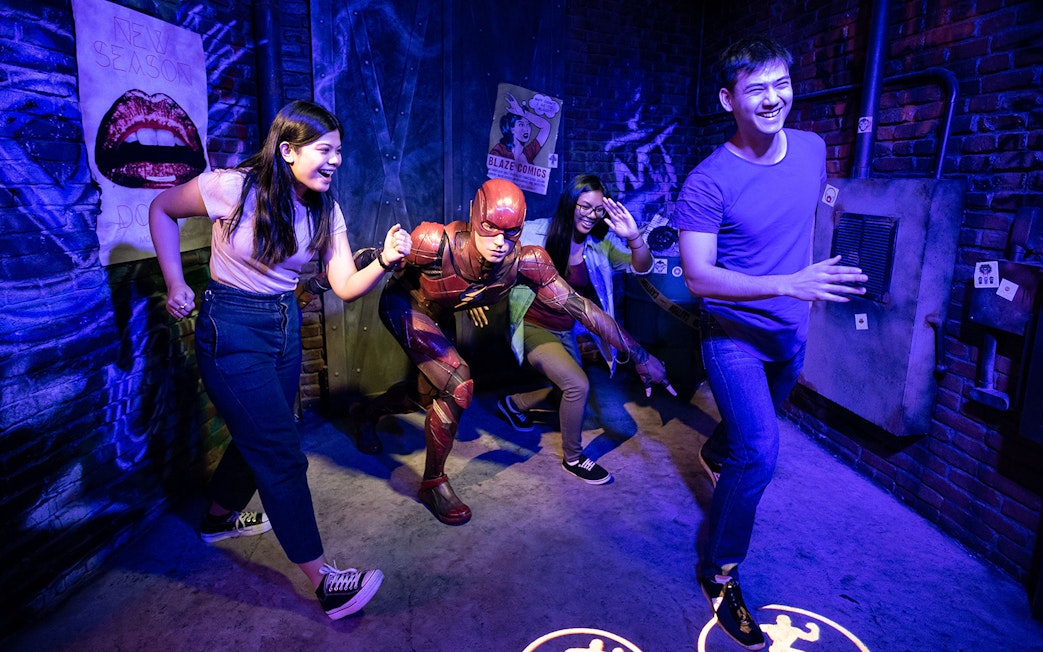 Visitors posing with superhero figure at Madame Tussauds Sydney.