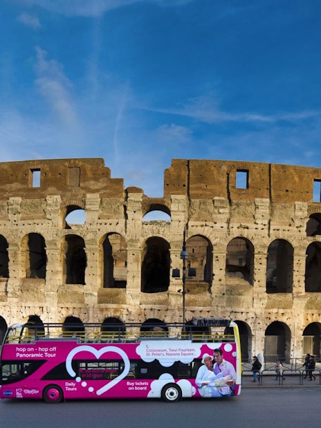 Hop-on hop-off tour bus in front of the Colosseum, Rome.