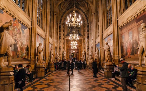 Visitors exploring the ornate interior of the UK Parliament during a guided closing time tour.
