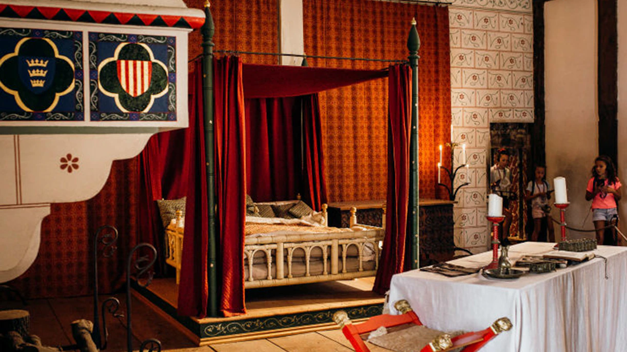 Tower of London royal bedroom with canopy bed and historical decor.