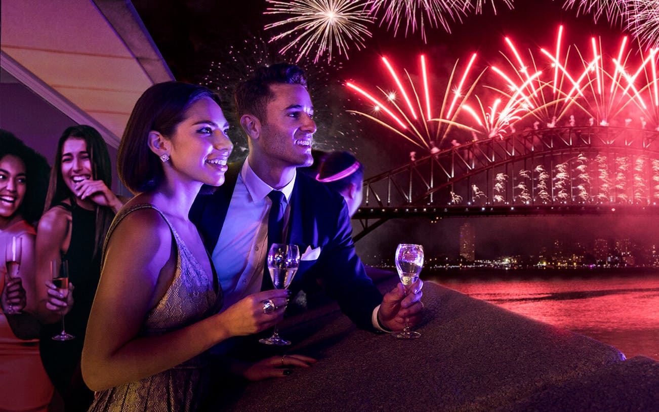 Couple enjoying fireworks over Sydney Harbour Bridge at New Year's Eve Opera Gala.